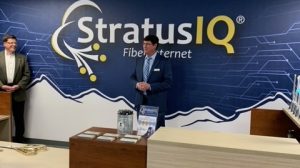 Two men standing in front of a sign that says stratus iq.