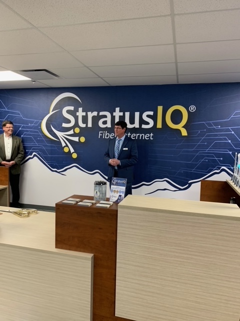 Two men standing in front of a sign that says stratus iq.