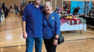 A man and woman posing for a photo in a gymnasium