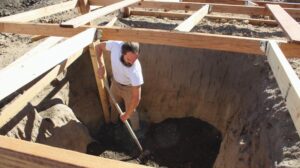 A man digging a hole in the ground with a shovel