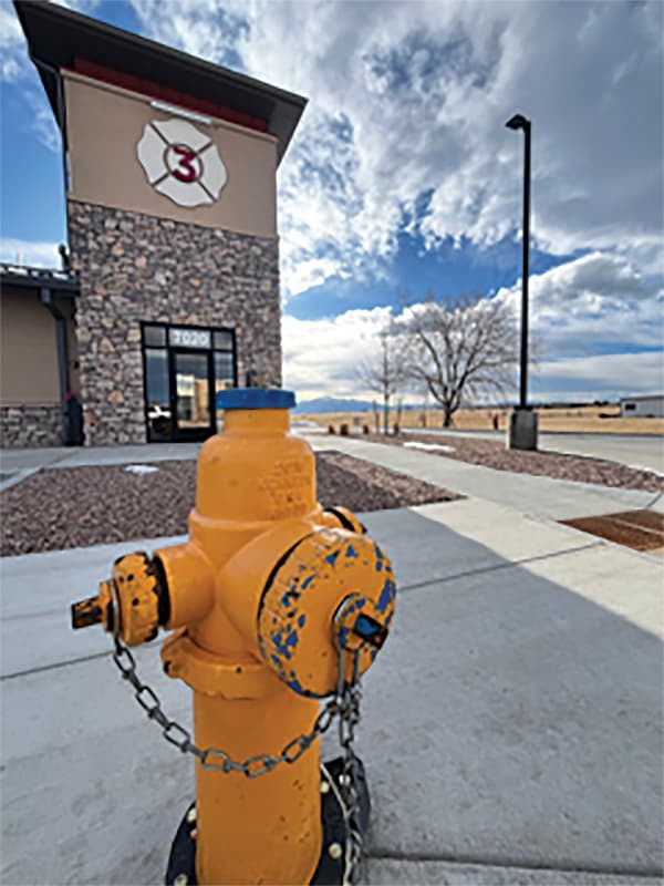 A yellow fire hydrant in front of a building