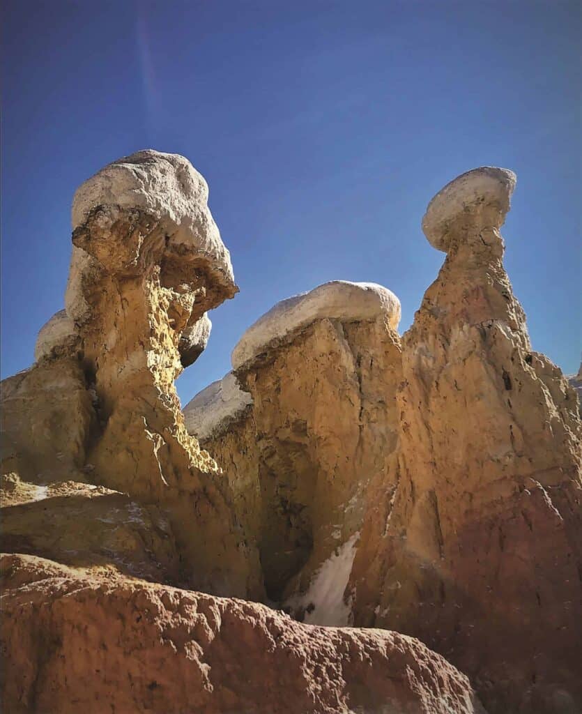 Three snow covered rock formations in the desert
