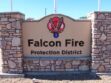 Signage for falcon fire protection district with a logo on a stone monument.