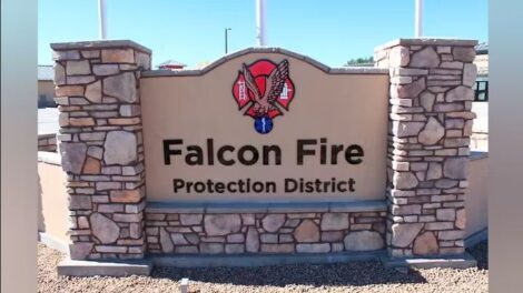 Signage for falcon fire protection district with a logo on a stone monument.