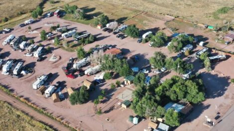 Aerial view of a rural rv park with several vehicles and trailers parked in designated spots.