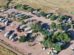 Aerial view of a rural rv park with several vehicles and trailers parked in designated spots.