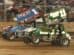 Two sprint cars racing side by side on a dirt track.