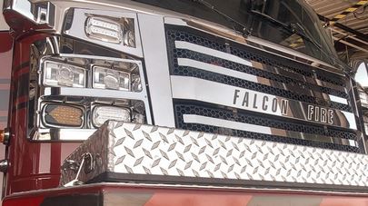 Front grille and headlights of a falcon fire department truck.