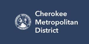 Logo of Cherokee Metropolitan District with an emblem representing water, a tree, and a gear, alongside the text "Cherokee Metropolitan District" on a navy blue background.