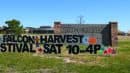 A sign reads "Falcon Harvest Festival Sat 10-4P" in front of Falcon High School, with fall-themed decorations on a grassy area.