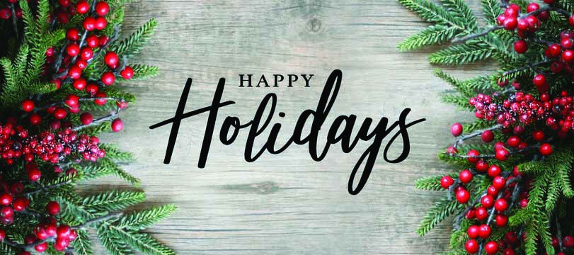 Festive greenery and red berries frame the words "Happy Holidays" on a wooden background.