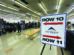 Job fair with booths set up in a large room. A sign points to Rows 10 and 11, labeled "Pikes Peak Workforce Center." People are visible in the background exploring the event.