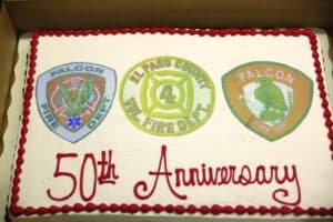 Rectangular cake with three fire department logos and "50th Anniversary" written in red icing.