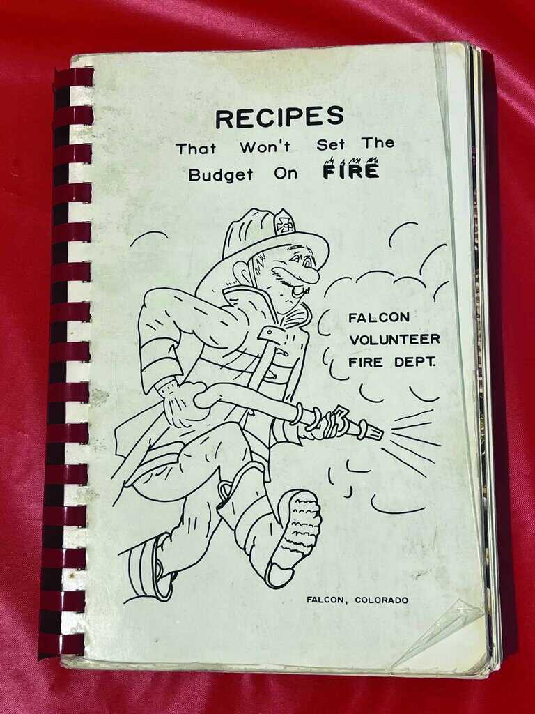 Spiral-bound cookbook titled "Recipes That Won't Set The Budget On Fire" featuring a cartoon firefighter, created by the Falcon Volunteer Fire Dept., Falcon, Colorado.