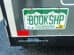 A Colorado license plate on a vehicle reads "BOOKSHP" in green letters, with white mountains in the background.