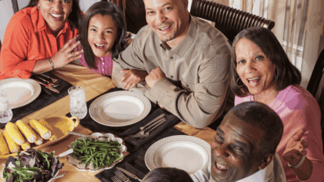 A family of six sits around a dinner table with plates of vegetables, smiling at the camera. Text reads: "National Eat Better Eat Together Month.