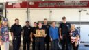 A group of Falcon Fire Protection District firefighters and civilians stand in front of a fire truck.